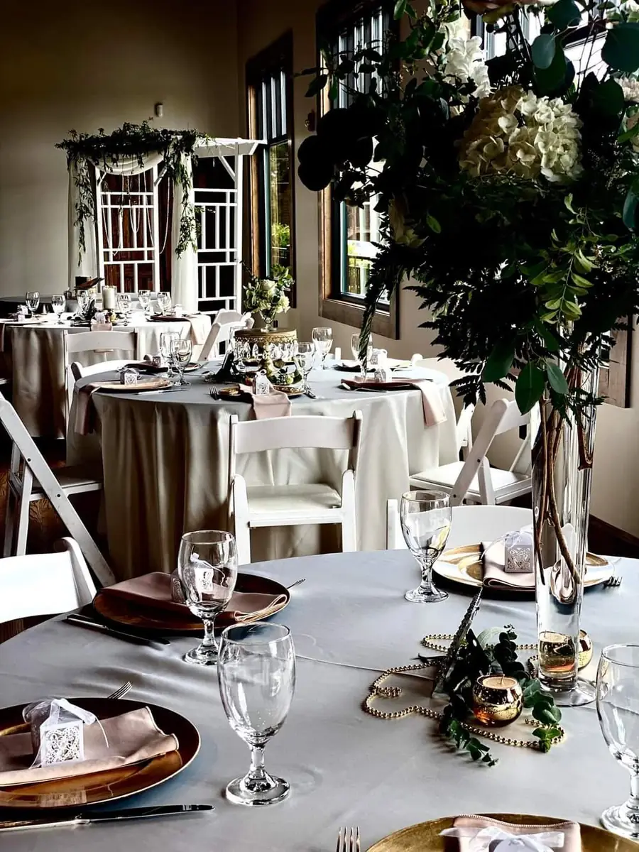 Banquet room set with tables, florals, and place settings