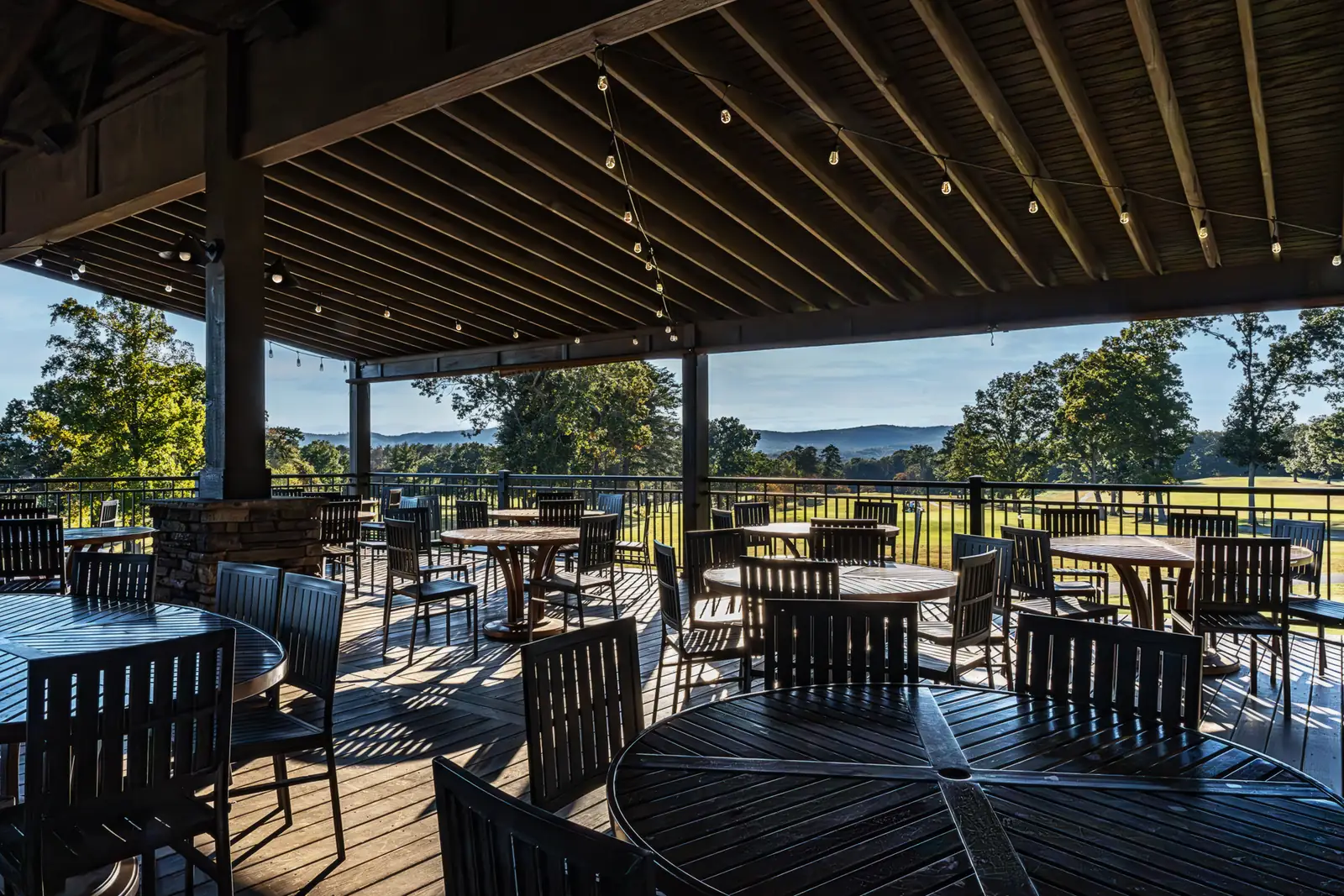 Covered outdoor deck with string lights overlooking the golf course and mountain views at Brushy Mountain Event Center in Taylorsville, NC