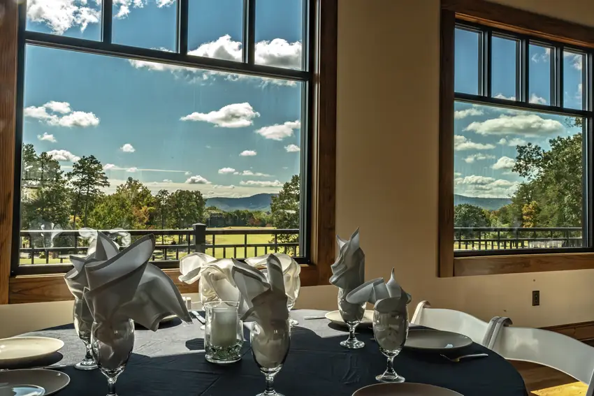 Table setting beside large windows framing the golf course and Blue Ridge mountain views